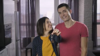 Yeni sallayarak mutlu genç yetişkin çift anahtar evi