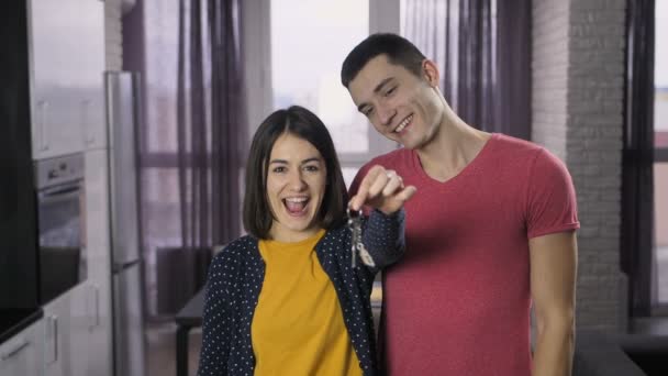 Delighted couple shaking keys and dancing — Stock Video