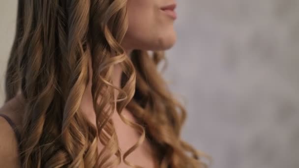 Крупним планом портрет жінки, що скручує світле волосся — стокове відео
