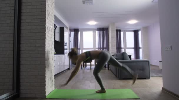 Junge Frau im Handstand zu Hause — Stockvideo