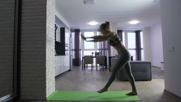 Jonge passen vrouw doet handstand in de buurt van muur thuis — Stockvideo