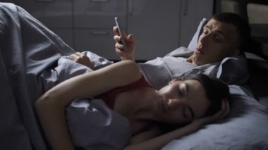 Karım uyandığında gergin adam cep telefonu gizler