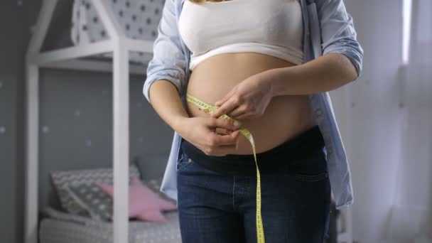 Mulher grávida medindo barriga grande com fita — Vídeo de Stock