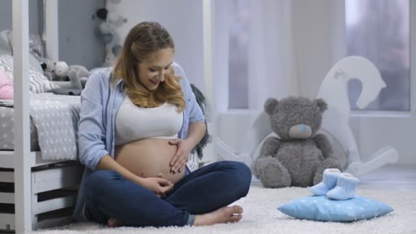 Gelukkig zwangere vrouwelijke gevoel baby duwen — Stockvideo