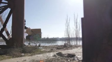 Evsiz erkek sepeti ile köprü altında yürüyüş