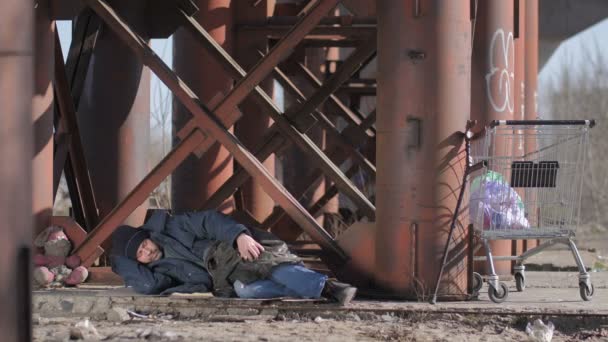 Homem sem-teto dormindo sob a ponte — Vídeo de Stock