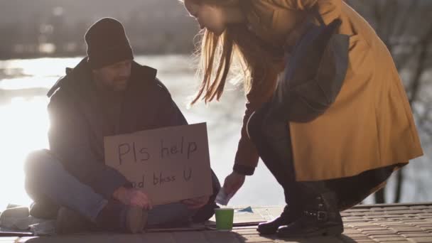 Dakloze bedelen man verbergen van contant geld in zijn zak — Stockvideo
