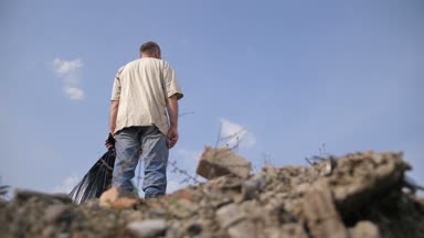 Üstünde tepe-in çöp yığını erkek ayakta düşük açılı