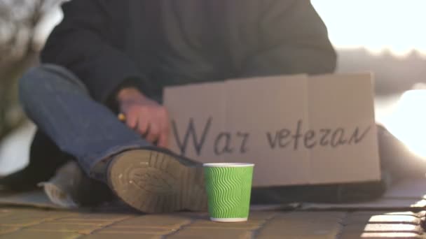 Közelkép lábak és kezek a koldulás háborús veterán — Stock videók