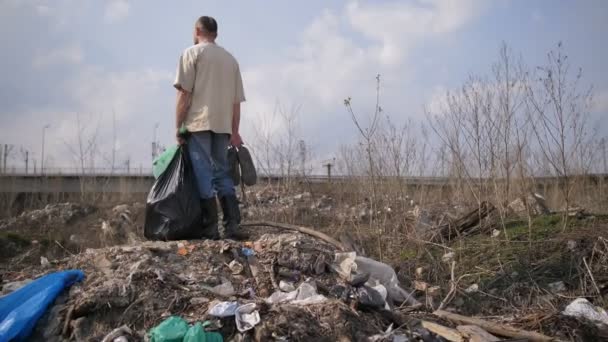 Muž, který stojí na kopci odpadků na skládku — Stock video