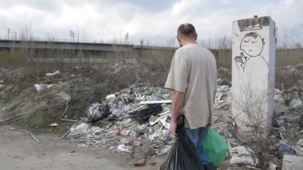 Ο άνθρωπος περπατώντας χωματερή με κάδους σκουπιδιών — Αρχείο Βίντεο