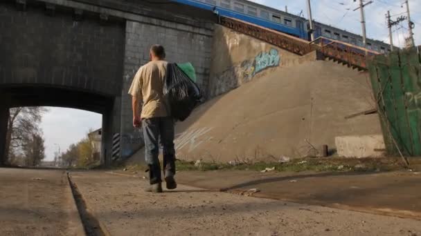 Vista trasera del hombre sin hogar caminando en la ciudad — Vídeos de Stock