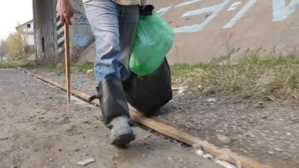 Крупный план мужских ног в поисках пластиковой бутылки — стоковое видео