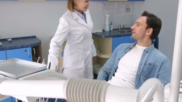 Mujer dentista saludo paciente masculino en la clínica — Vídeo de stock