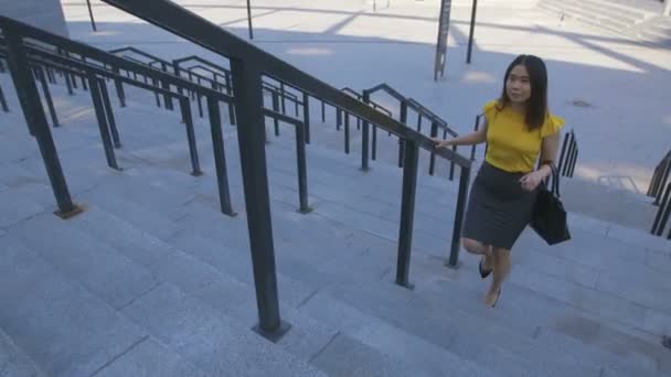 Азиатка в спешке поднимается по лестнице на работу — стоковое видео