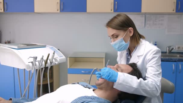 Zahnarzt in Maske zur Behandlung der Zahnhöhle des Patienten — Stockvideo