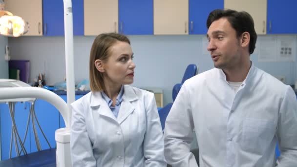 Medicii stomatologi vorbesc apoi zâmbind la cameră — Videoclip de stoc