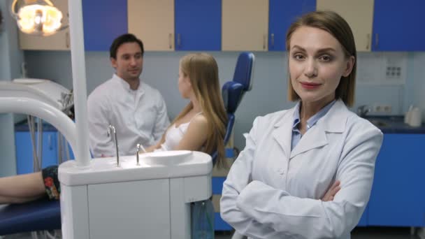 Jolie dentiste féminine souriante avec les bras croisés — Video