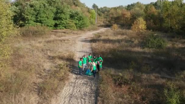 Drone vlucht over groep vrijwilligers tussen bos — Stockvideo