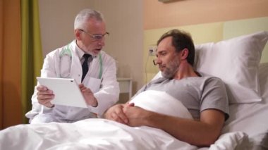 Erkek doktor hastaya MR sonuçlarını gösteriyor