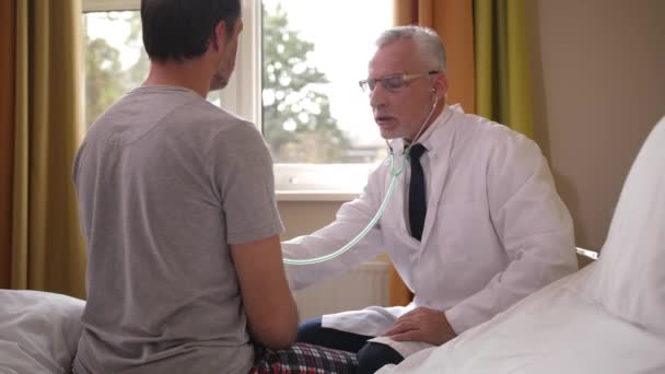 Arts die stethoscoop gebruikt om patiënt in afdeling te onderzoeken — Stockvideo