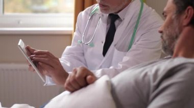Yaşlı doktor ve hasta beyin taramalarını izliyor.