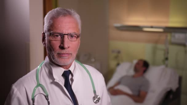 Portrait of serious aging doctor in patients ward — Stock Video