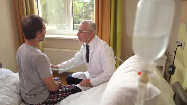 Lékař naslouchá pacientovi se stetoskopem — Stock video