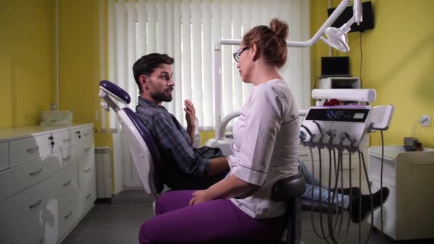Человек, посещающий стоматолога в стоматологической клинике — стоковое видео