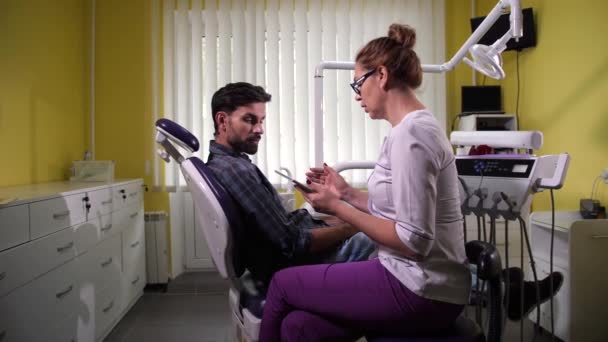 Estomatólogo que muestra resultados del diagnóstico al paciente — Vídeos de Stock