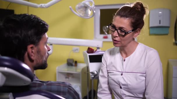 Client masculin sur rendez-vous avec un dentiste en clinique — Video