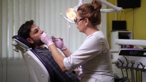 Dentista haciendo anestesia al paciente en el consultorio — Vídeos de Stock