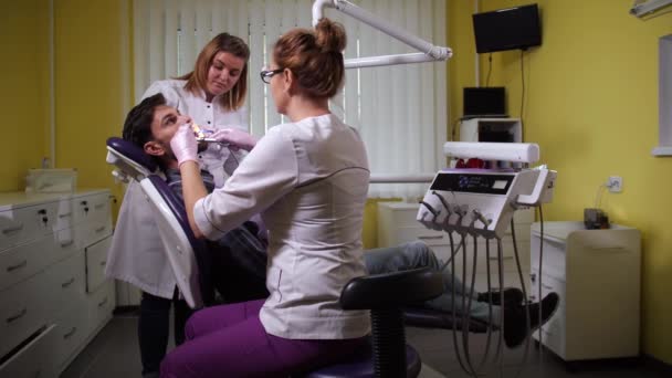 Paciente durante la limpieza dental en clínica dental — Vídeos de Stock