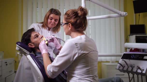 Dentista limpieza de dientes del paciente en el consultorio dental — Vídeos de Stock