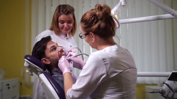 Extirpación estomatológica de caries al paciente en clínica — Vídeo de stock