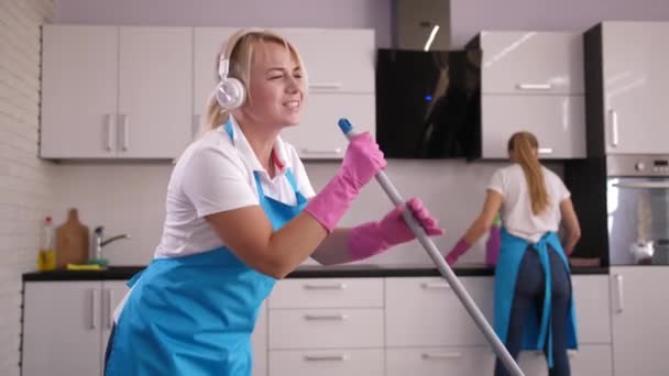 Temizlikçi kadın evde yerleri silerken şarkı söylüyor. — Stok video
