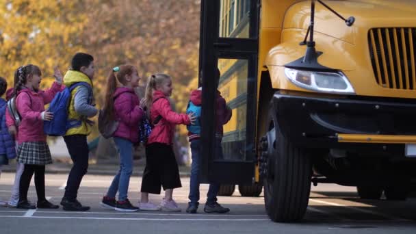 Skolbuss öppna dörrar för olika små elever — Stockvideo