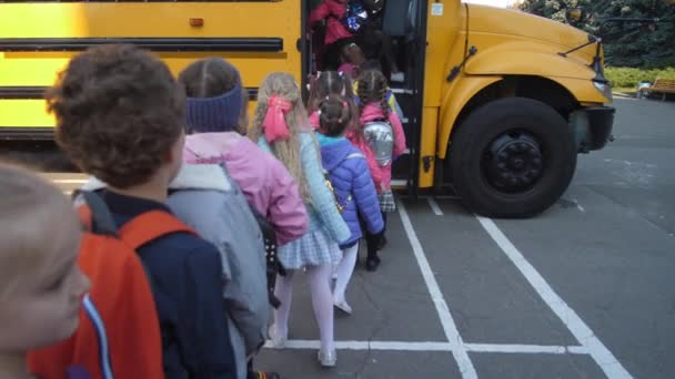 Alignés enfants d'âge élémentaire autobus pensionnat — Video