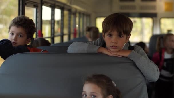 Skolpojkar som väntar på att komma hem till skolbussen — Stockvideo