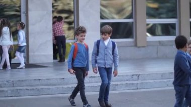 Okul çağındaki çocuklar okuldan ayrılırken konuşurlar.
