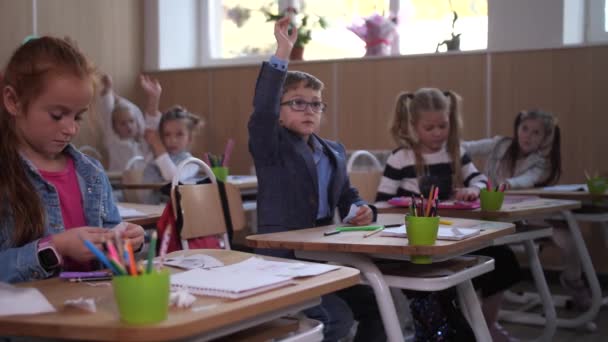 Slimme schooljongen hand in hand om vraag te beantwoorden — Stockvideo