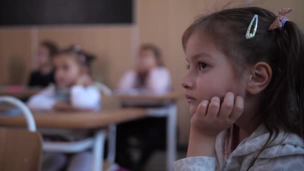 Écolière ciblée écoutant le professeur en leçon — Video