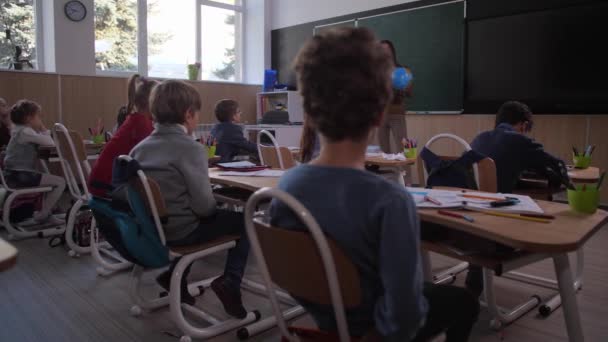 Alunos ouvindo professor em aula de geografia — Vídeo de Stock