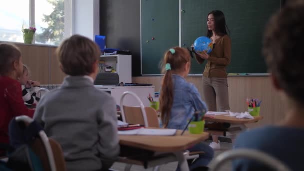 Alunos estudando geografia durante a aula de escola — Vídeo de Stock