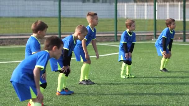 Equipo de fútbol infantil calentándose en el campo de fútbol — Vídeo de stock