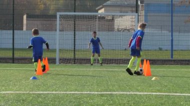 Genç futbolcular futbol sahasında antrenman yapıyor.