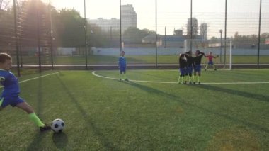 Yetenekli genç futbolcu penaltıdan gol atıyor.