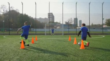 Genç futbolcular gol atmak için antrenman yapıyorlar