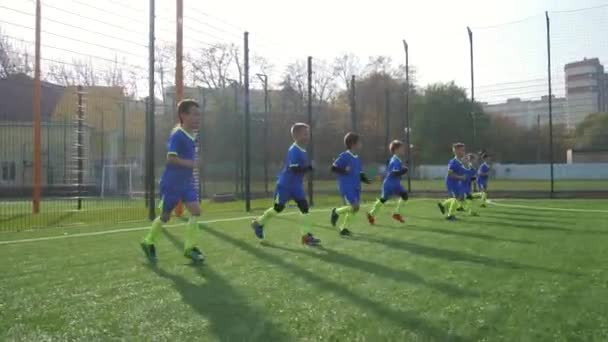 Jóvenes futbolistas corriendo por el campo — Vídeos de Stock