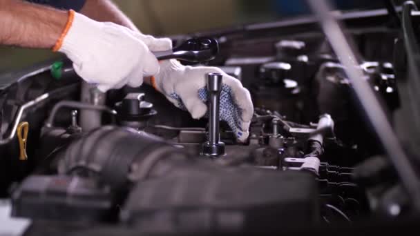 Reparateur arbeitet mit Schraubenschlüssel unter Motorhaube — Stockvideo